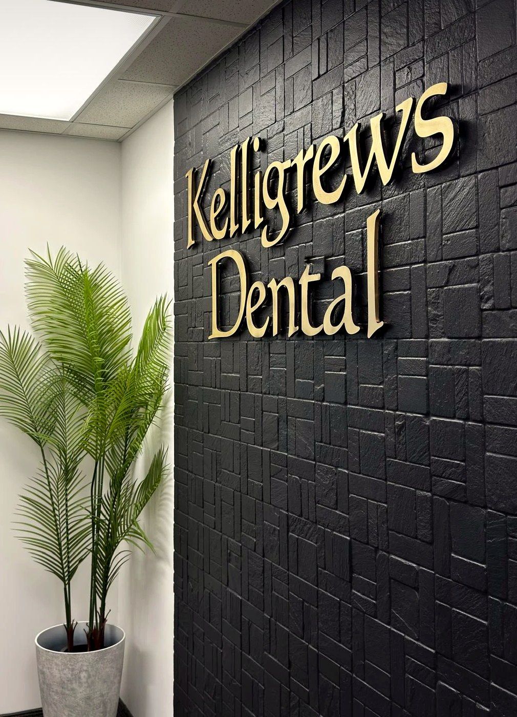 The Kelligrews Dental sign in gold letters on a black stone wall at the clinic